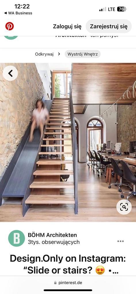 Nowoczesne biuro z nietypowymi schodami: kombinacja drewnianych stopni i metalowej zjeżdżalni. Kobieta zjeżdża na zjeżdżalni. W tle przestrzeń biurowa z biurkami i krzesłami.