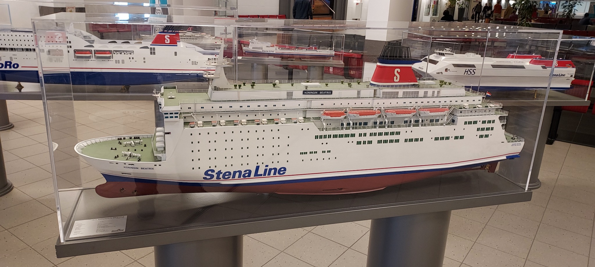 Model promu Stena Line 'Koningin Beatrix' w przezroczystej gablocie, widoczne inne modele promów w tle.