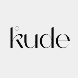 Eleganckie logo firmy 'Kude' w czarnym kolorze na jasnoszarym tle, z charakterystycznym okręgiem nad literą 'k'.