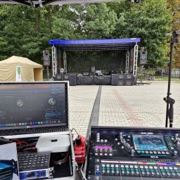 NEXA ENERGY Leszek Korycki - Scena plenerowa z nagłośnieniem i sprzętem DJ-skim. Widoczny mikser Allen&Heath SQ-6, laptop LG z oprogramowaniem muzycznym. W tle drzewa i namiot imprezowy.