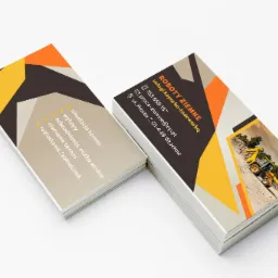 Stos wizytówek firmy ROBOTY ZIEMNE z usługami koparko-ładowarką, z geometrycznym wzorem i zdjęciem koparki w trakcie pracy.