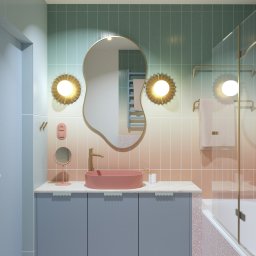 BAFO pracownia - Pastelowa łazienka z umywalką w odcieniach różu, ozdobnym lustrem i złotymi akcentami. Gradientowe kafelki na ścianach dodają unikalnego charakteru.