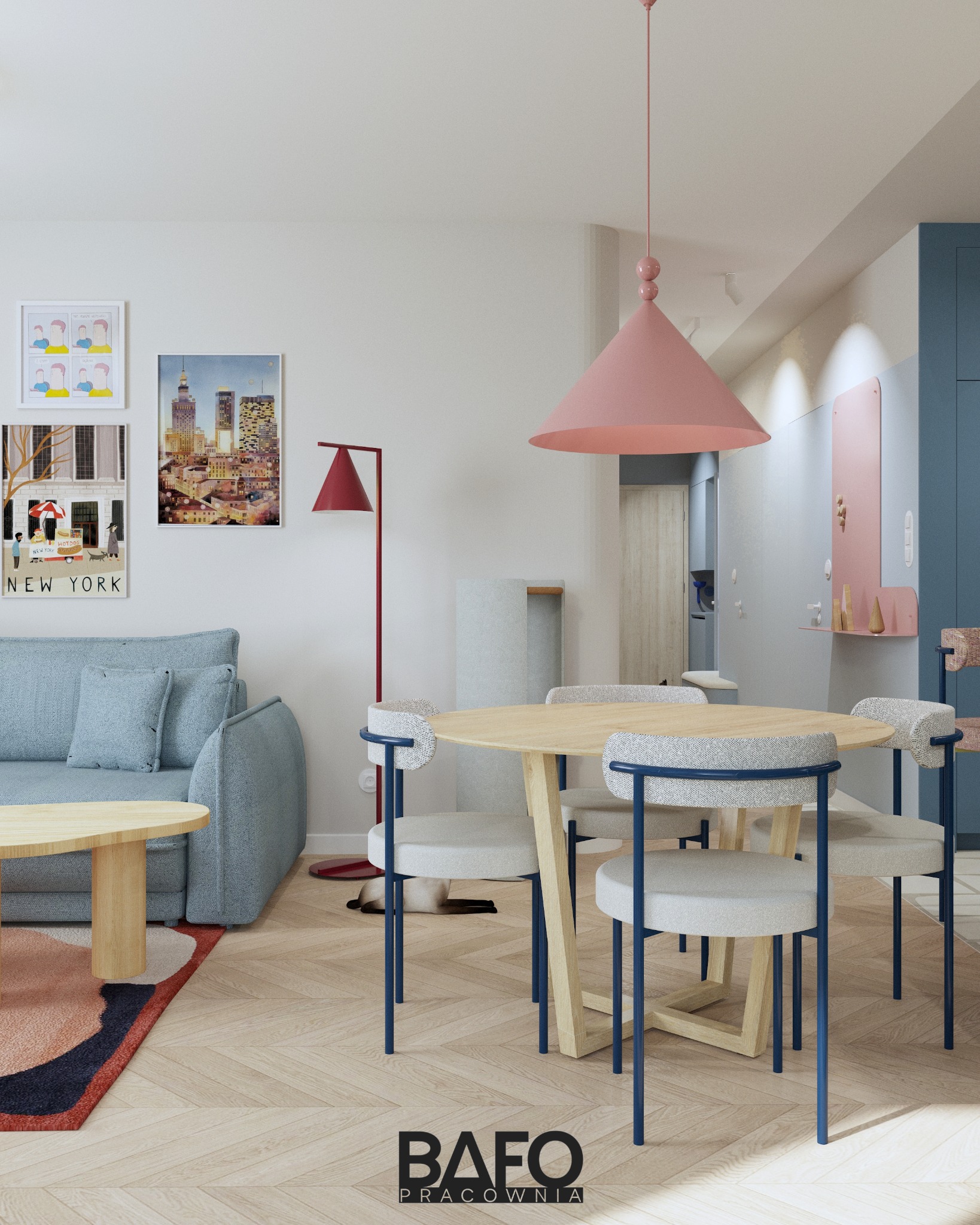 Jasne wnętrze mieszkania z okrągłym stołem i niebieskimi krzesłami. Na ścianie grafiki z motywami miejskimi, nad stołem różowa lampa. Parkiet w jodełkę.