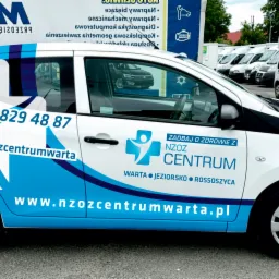 Samochód oklejony folią z niebiesko-białą grafiką i danymi kontaktowymi NZOZ Centrum, zaparkowany na parkingu z innymi pojazdami w tle.