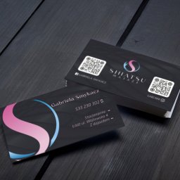 SOLO STUDIO Studio Graficzne Marcin Mikołajczyk - Stos wizytówek na ciemnym drewnianym tle, z logo Shiatsu Masaże i kodami QR.