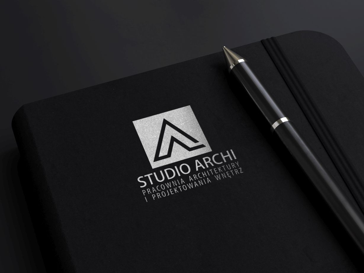 Czarny notatnik z srebrnym logo 'Studio Archi' i długopisem, prezentacja identyfikacji wizualnej firmy architektonicznej.