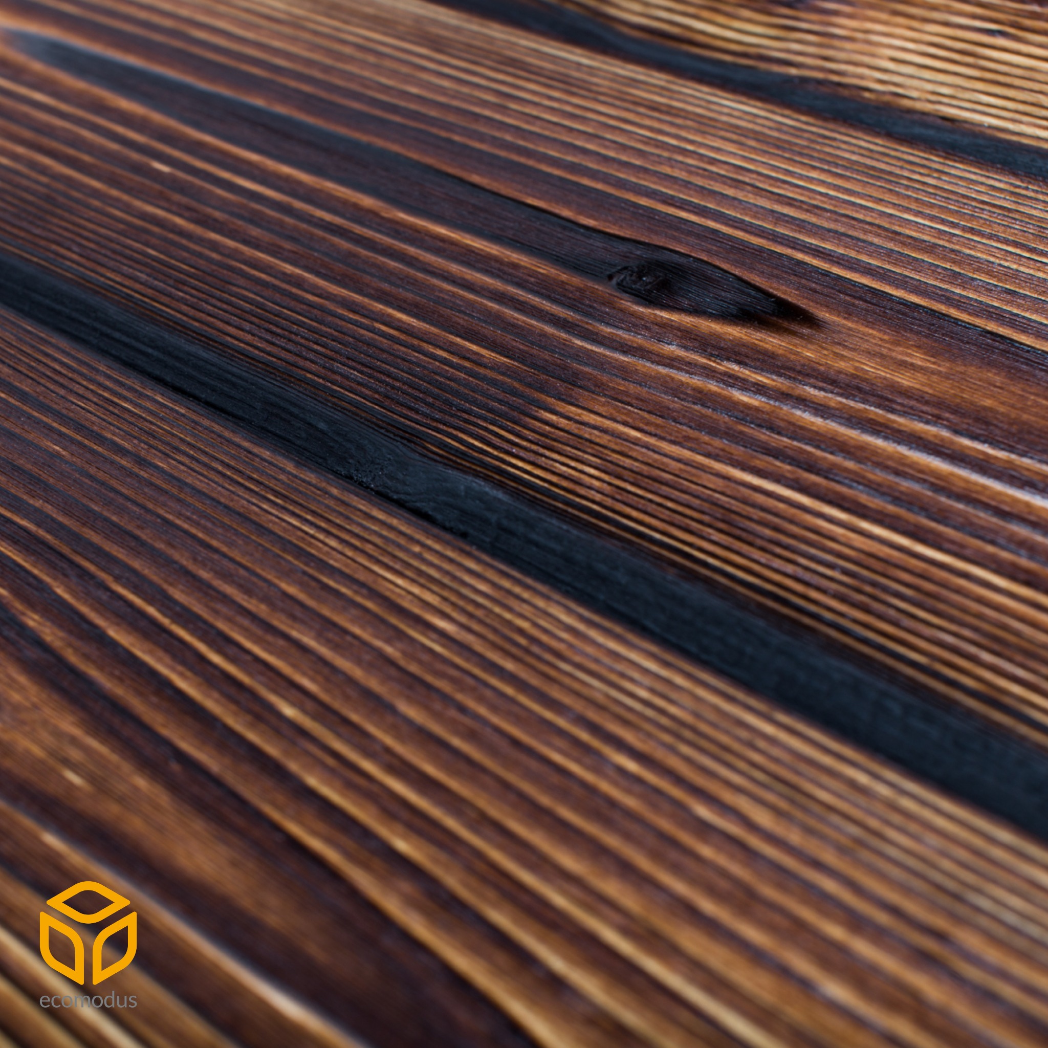 Opalona deska z widocznym usłojeniem, ułożona diagonalnie z logo firmy w lewym dolnym rogu.