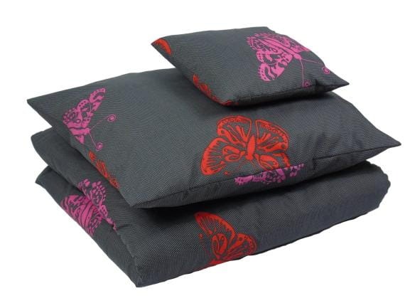 Stos szarych poduszek i pościeli z nadrukowanymi motylami w kolorze różowym i czerwonym, leżący na białym tle.