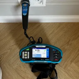 Miernik Metrel EurotestXD MI 3155 podczas pomiaru gniazdka elektrycznego. Widoczny wynik pomiaru na ekranie urządzenia.