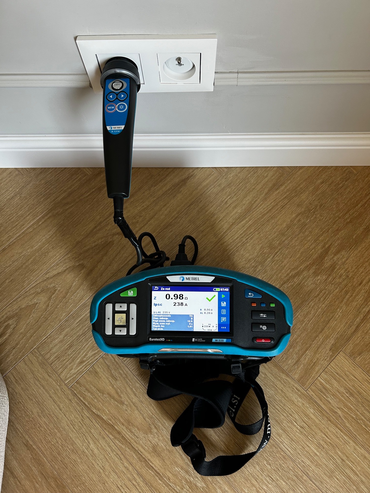 Miernik Metrel EurotestXD MI 3155 podczas pomiaru gniazdka elektrycznego. Widoczny wynik pomiaru na ekranie urządzenia.