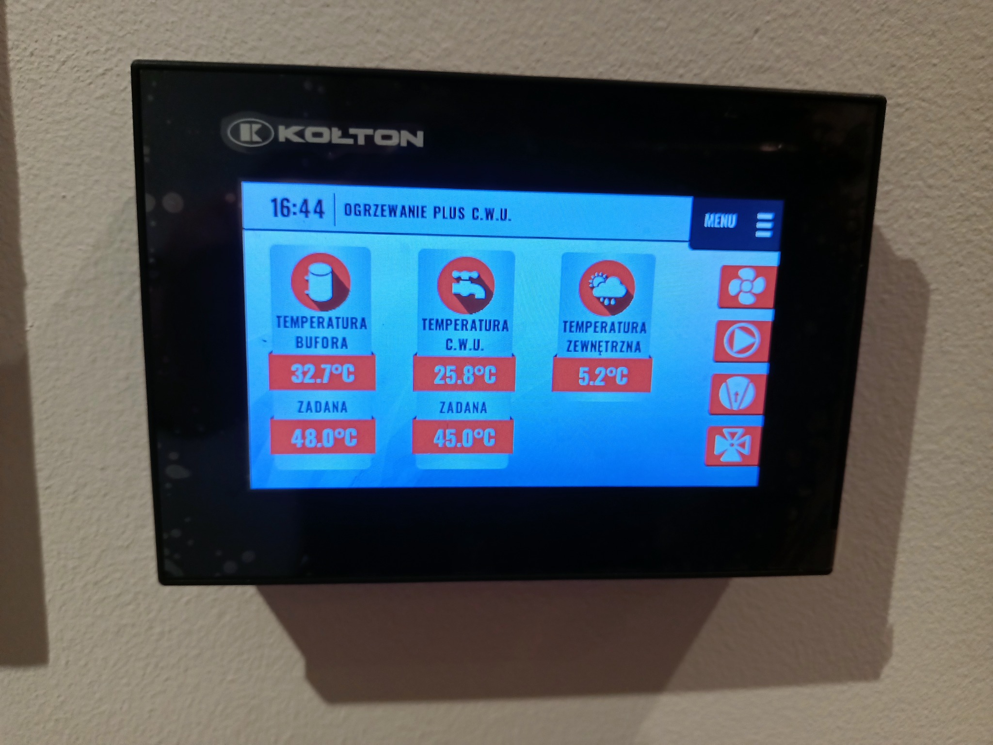 Panel sterowania systemu grzewczego Kolton z wyświetlanymi temperaturami bufora, C.W.U. i zewnętrzną, ustawionymi wartościami zadanymi oraz menu.
