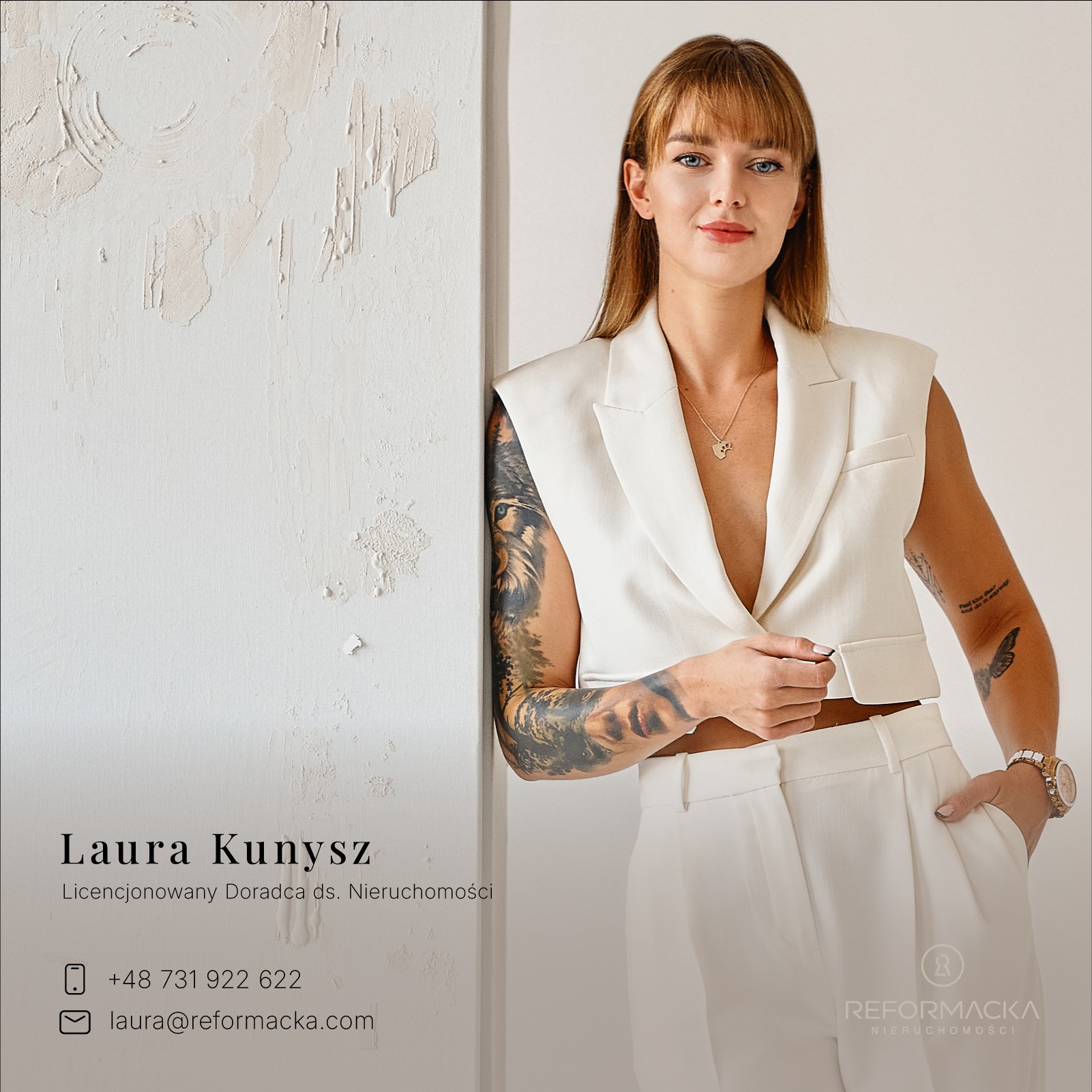 Portret kobiety, licencjonowanego doradcy ds. nieruchomości Laury Kunysz, w białym garniturze, z tatuażami na ramionach, opierającej się o ścianę z fakturą, w tle logo firmy Reformacka Nieruchomości.