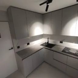 Nowoczesna kuchnia w odcieniach szarości z marmurowym backsplashiem, czarną armaturą i płytą indukcyjną, oświetlona punktowo z sufitu, widoczne gniazdka elektryczne wkomponowane w płytki.