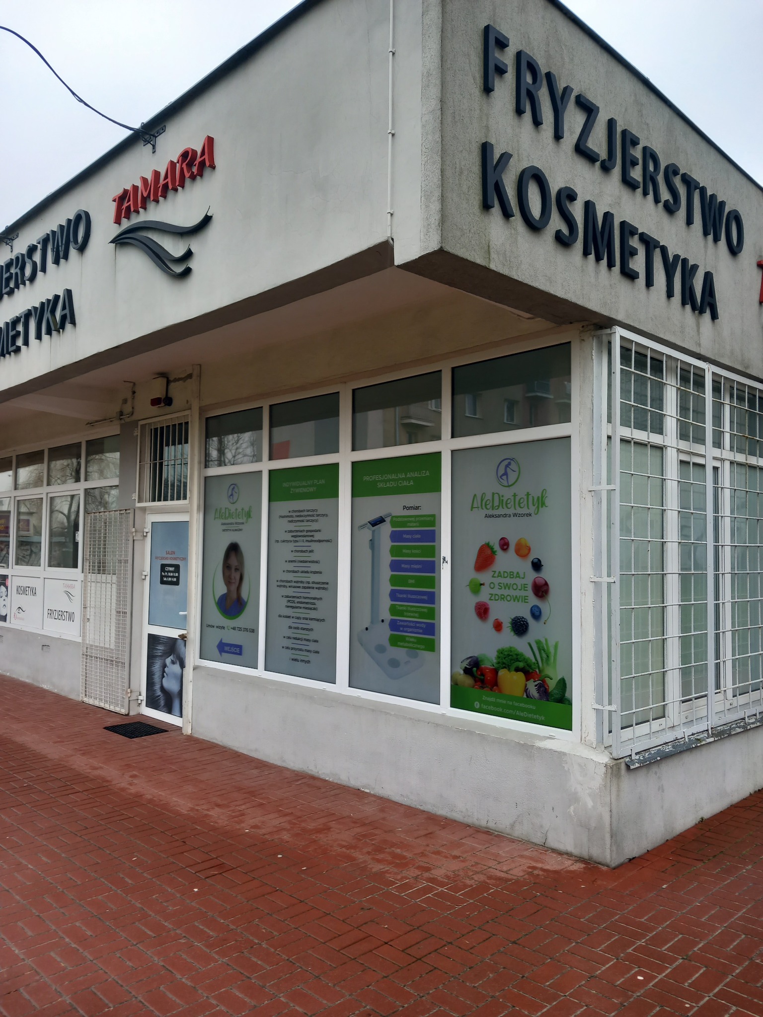 Fasada budynku z napisem 'Fryzjerstwo Kosmetyka Tamara', okna z reklamami gabinetu, analiza składu ciała oraz indywidualne plany żywieniowe.