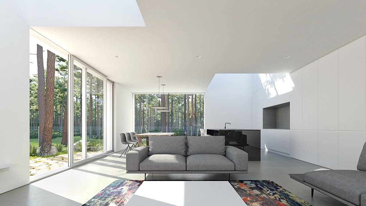 Jasne wnętrze domu w Katowicach z dużymi oknami wychodzącymi na las, szara sofa na tle białych ścian i zabudowy kuchennej, oświetlenie naturalne i minimalistyczny design.