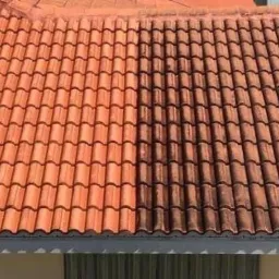 Częściowo wyczyszczony dach z czerwonej dachówki, ukazujący różnicę między brudną a czystą powierzchnią.