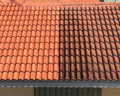 Częściowo wyczyszczony dach z czerwonej dachówki, ukazujący różnicę między brudną a czystą powierzchnią.