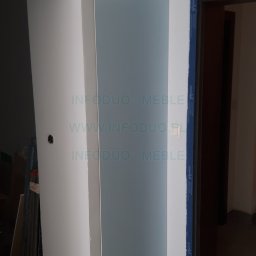 Infoduo Spółka z Ograniczoną Odpowiedzialnością - Narożna zabudowa z błękitnymi frontami, widoczna w trakcie montażu, z elementami konstrukcyjnymi i narzędziami w tle oraz logo firmy na powierzchni.