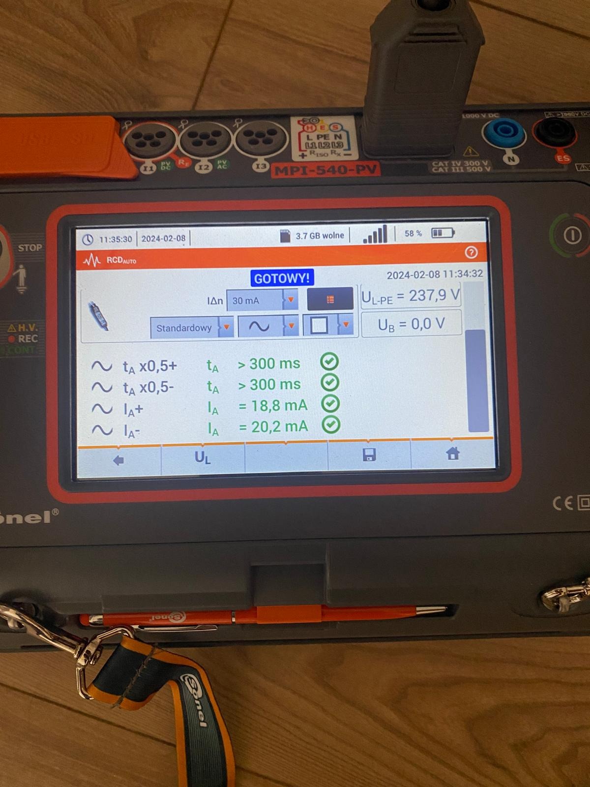 Miernik elektryczny Sonel MPI-540-PV z wyświetlonymi wynikami pomiarów parametrów elektrycznych, widoczne wartości napięcia U L-PE i prądu I A.