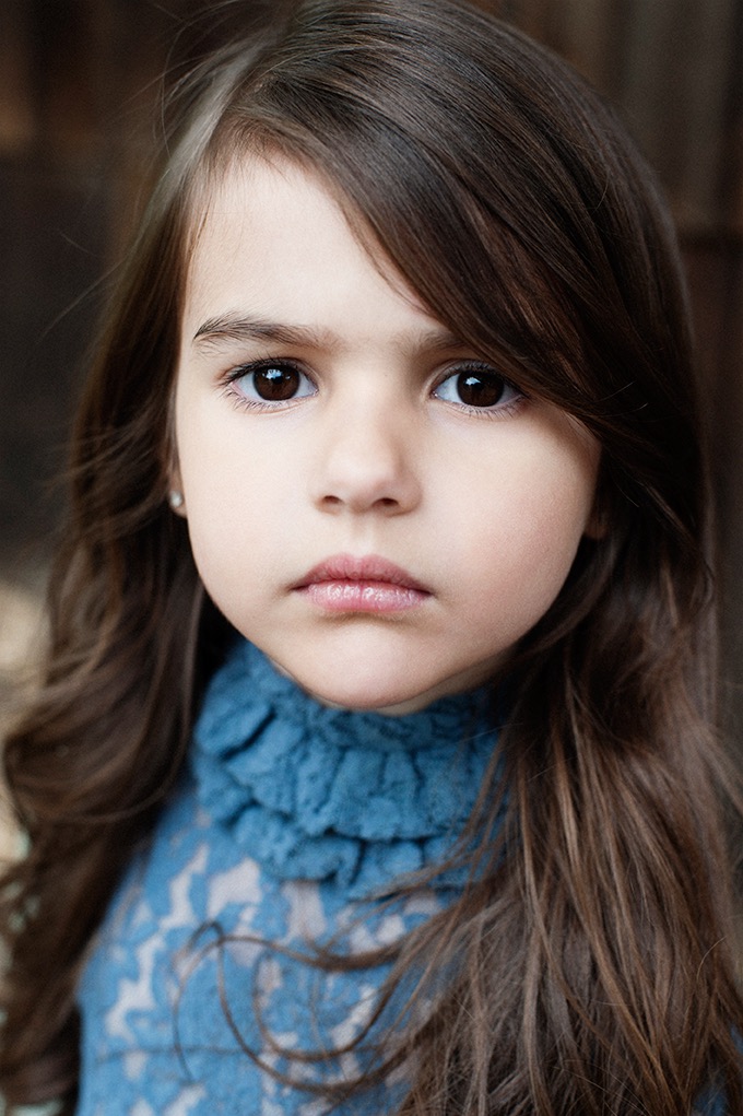 Portret dziewczynki z brązowymi włosami i brązowymi oczami, ubranej w błękitną bluzkę z koronką, wykonany w Mielcu.