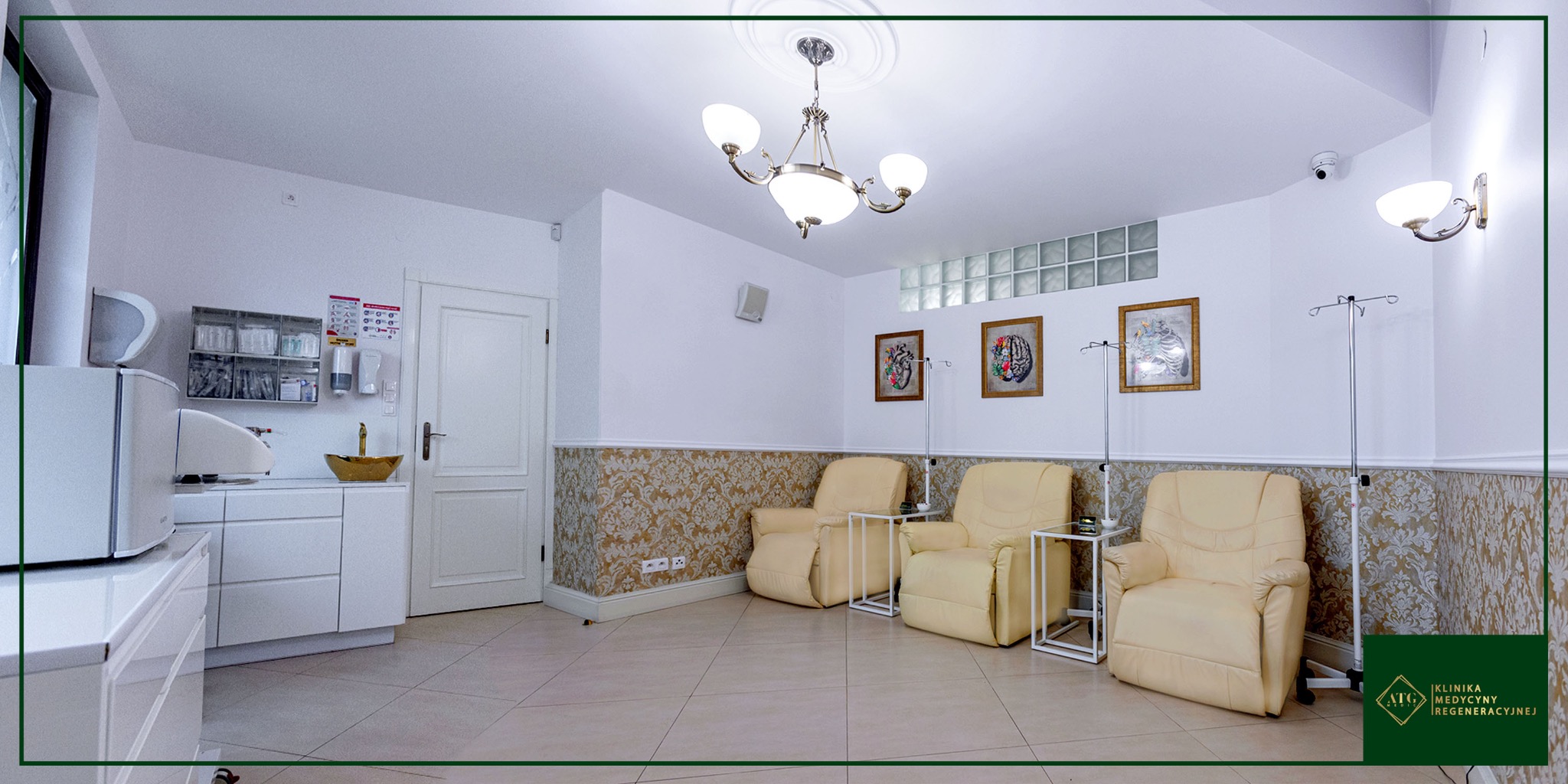 Jasne wnętrze gabinetu z trzema fotelami relaksacyjnymi, stolikami, stojakami do kroplówek, umywalką w kolorze złota i dekoracyjnymi obrazami na ścianie.