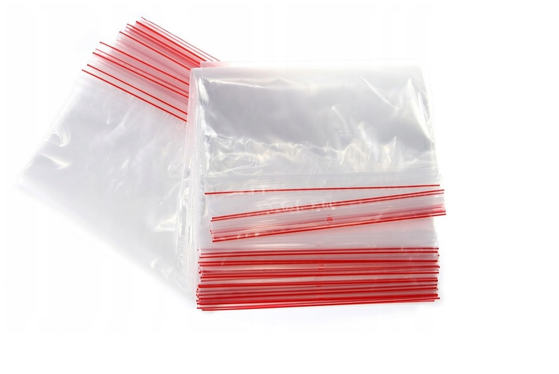 Stos przezroczystych woreczków strunowych z czerwonymi paskami zamknięcia na białym tle, ułożonych warstwami.