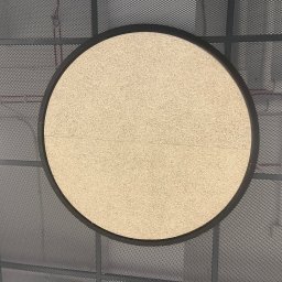 Fast Build by Roman Vynnyk - Okrągły panel akustyczny z jasnego drewna zamontowany na metalowej siatce sufitowej w biurze.