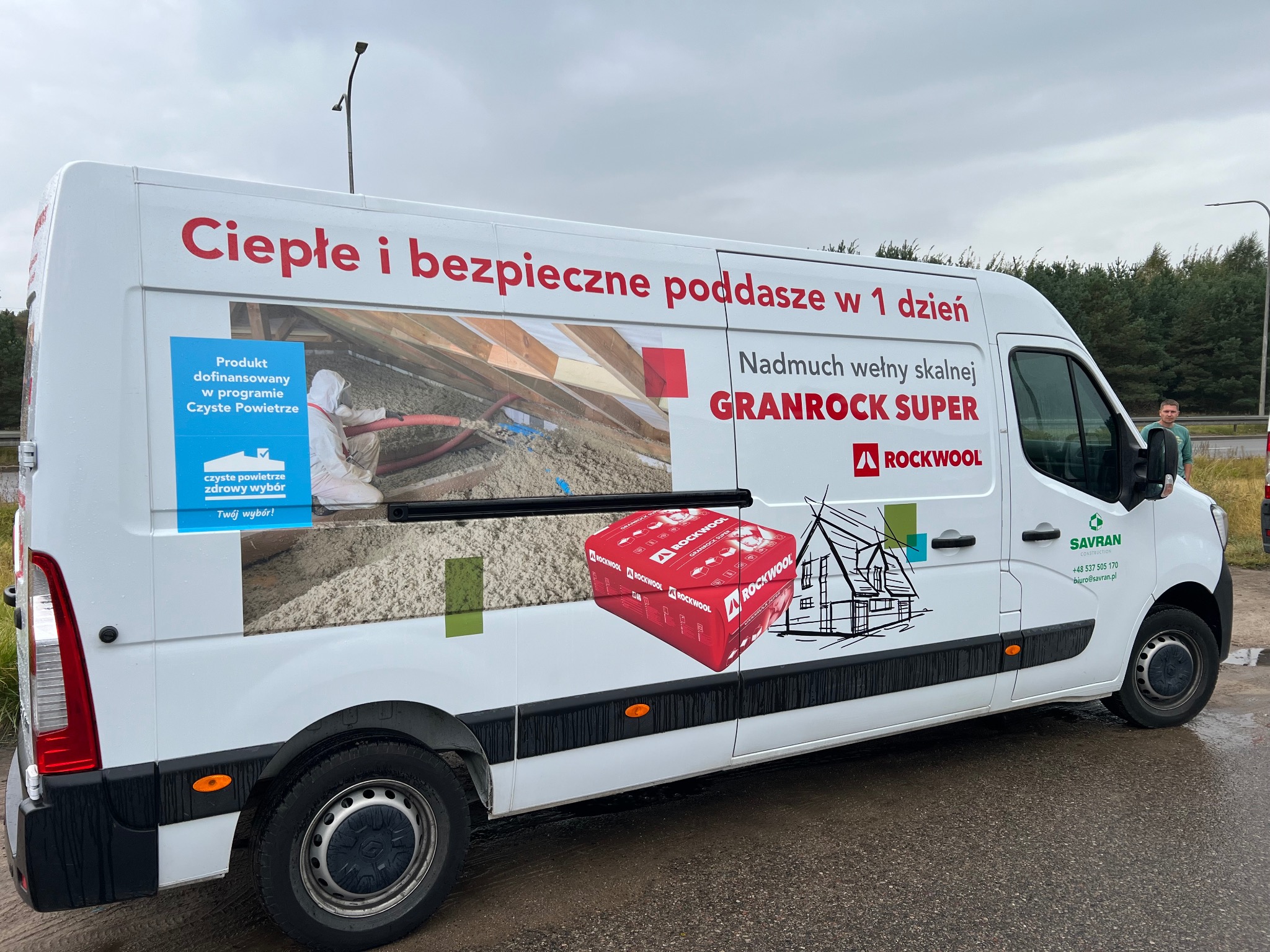 Reklamowy van firmy z Gdańska, prezentujący usługę ocieplania poddasza wełną skalną Granrock Super firmy Rockwool, z hasłem 'Ciepłe i bezpieczne poddasze w 1 dzień' oraz informacją o dofinansowaniu...