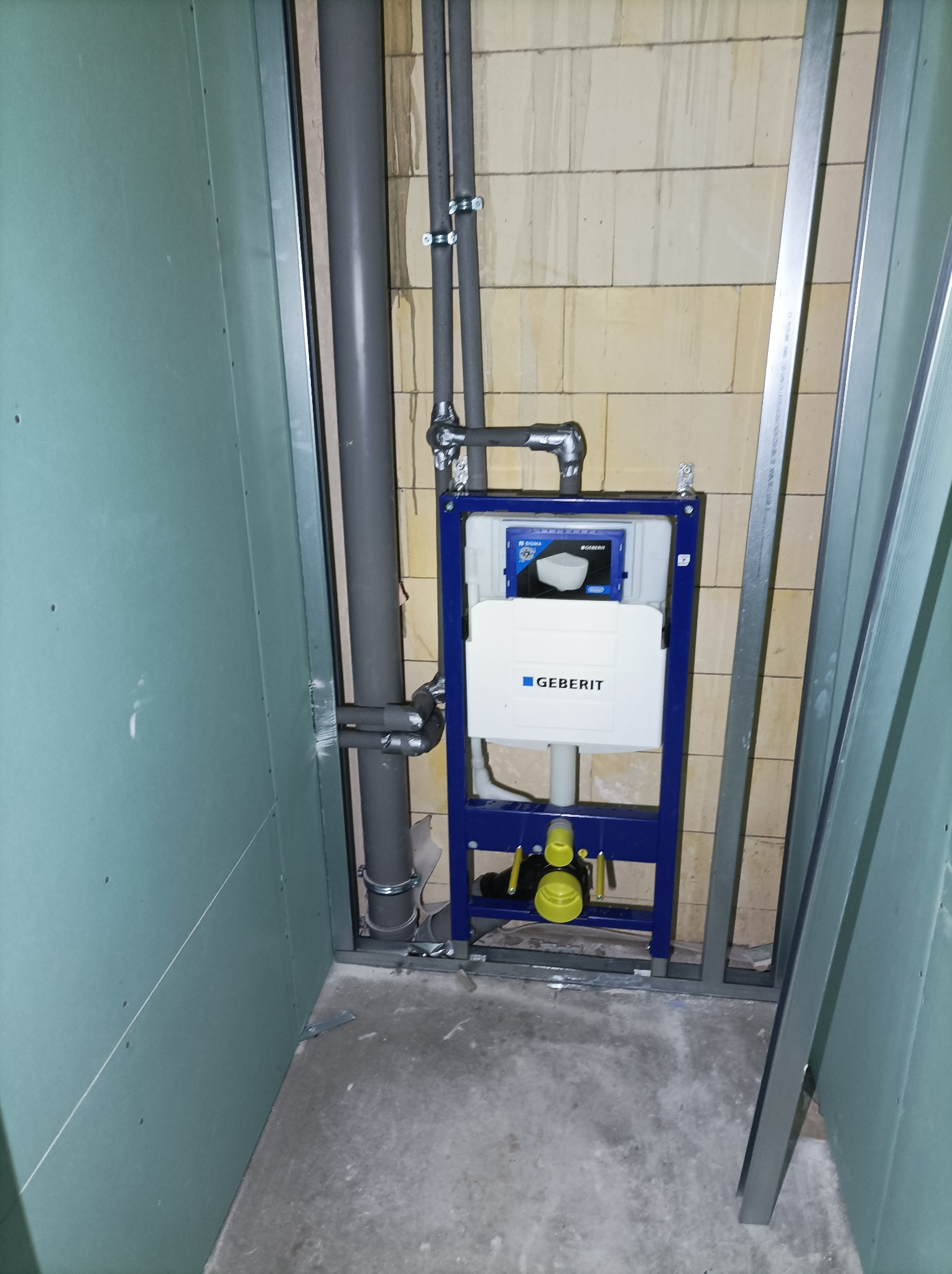 Stelaż podtynkowy Geberit zamontowany w trakcie remontu łazienki, widoczne rury kanalizacyjne i konstrukcja z profili stalowych pod płyty gipsowo-kartonowe.