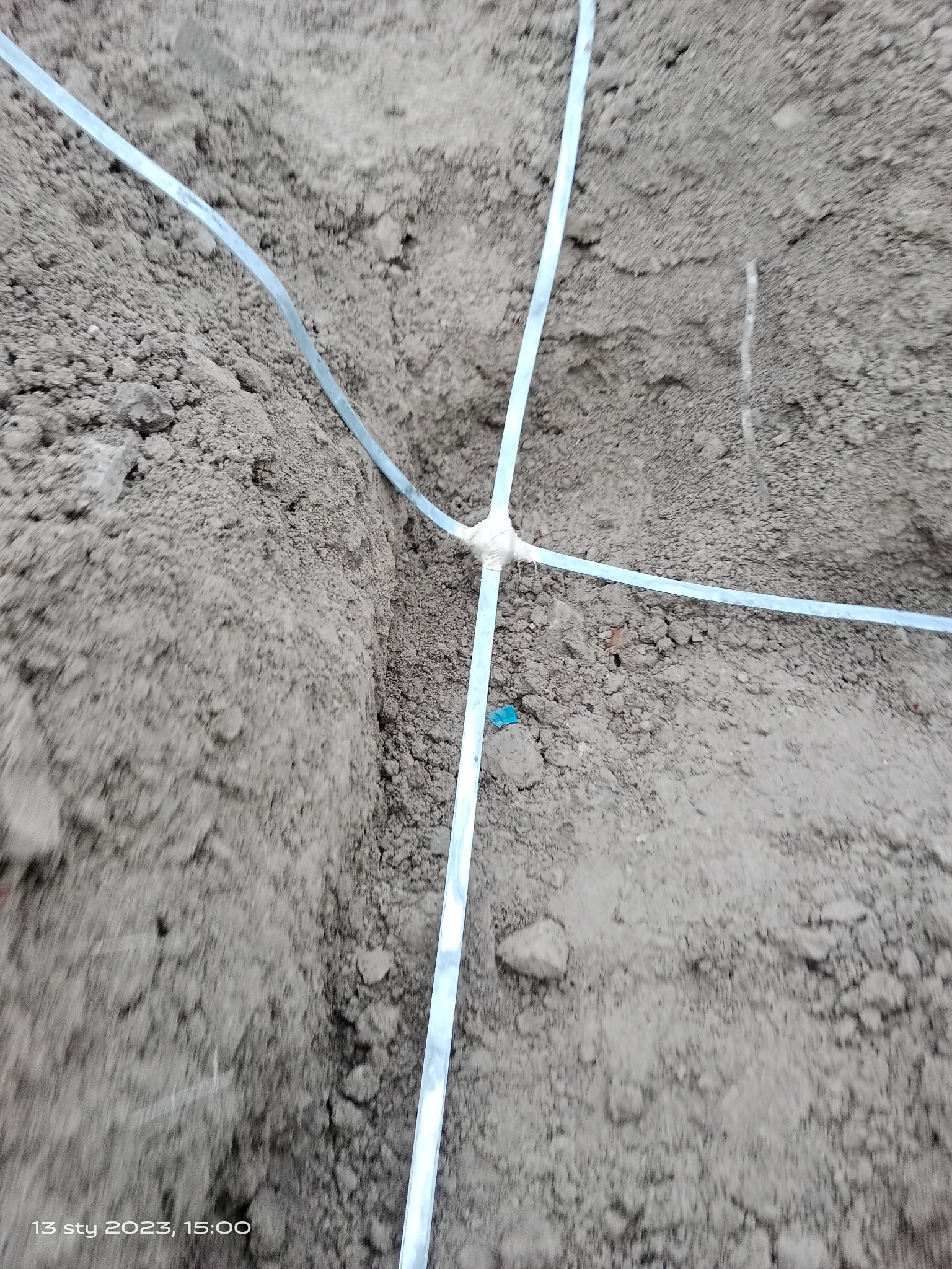 Grunt z wyznaczonymi liniami pod przyłącze elektryczne, z widocznym miejscem łączenia przewodów.