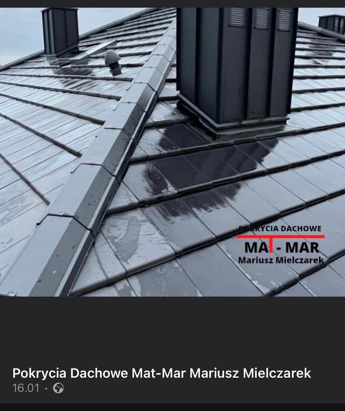 Błyszczące, grafitowe dachówki ceramiczne na skośnym dachu z kominami, widoczne logo firmy dekarskiej na pokryciu.