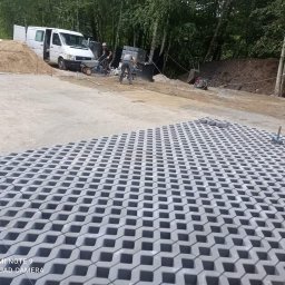 Mój raj - Montaż ażurowych płyt betonowych na przygotowanym podłożu, widoczny fragment ułożonej powierzchni, pracownicy w tle i biały bus