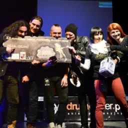 Zespół muzyczny odbiera czek o wartości 2000 zł za wygraną na XX Mayday Rock Festival Głogów 2016, trzymając urnę na głosy