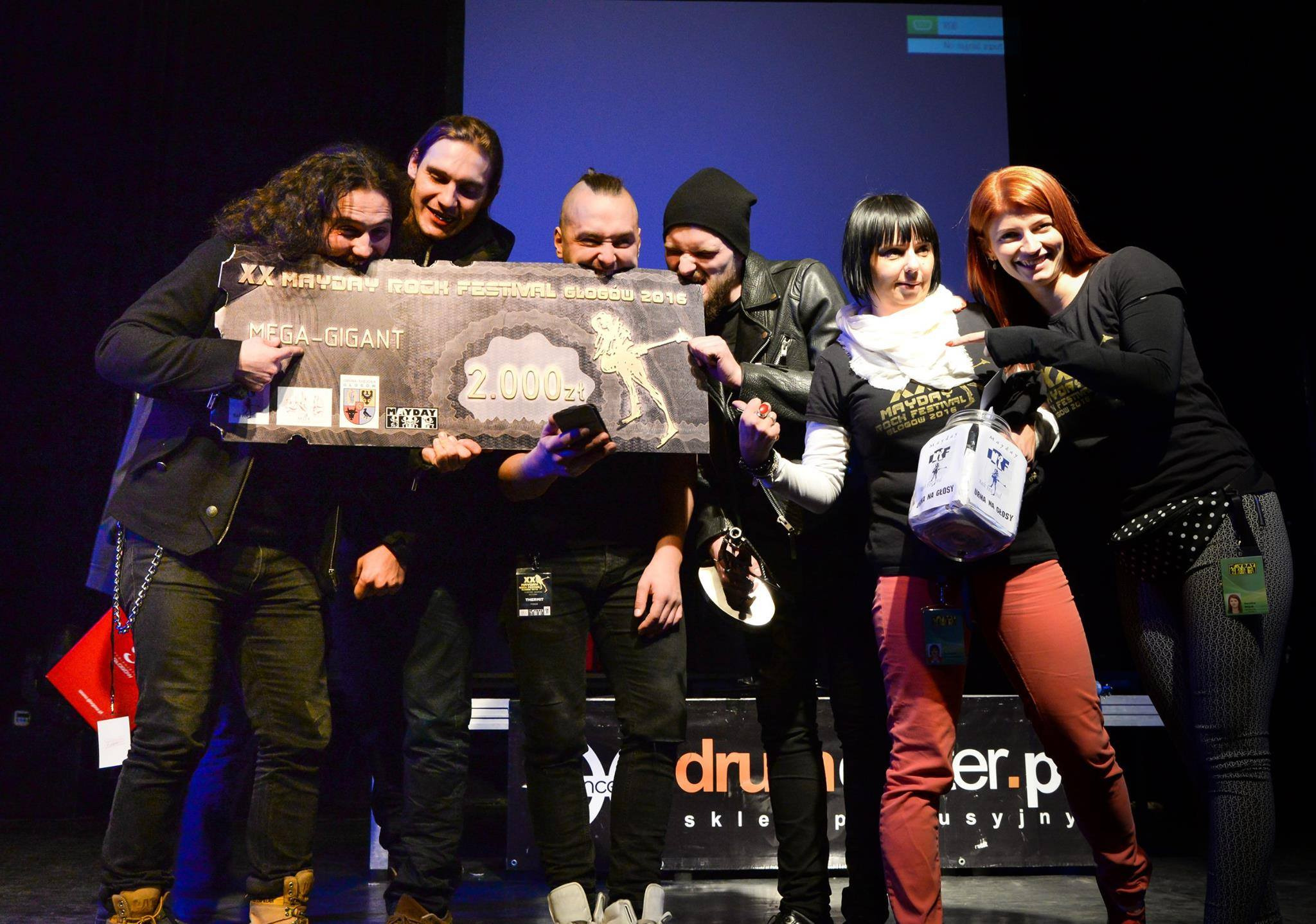 Zespół muzyczny odbiera czek o wartości 2000 zł za wygraną na XX Mayday Rock Festival Głogów 2016, trzymając urnę na głosy