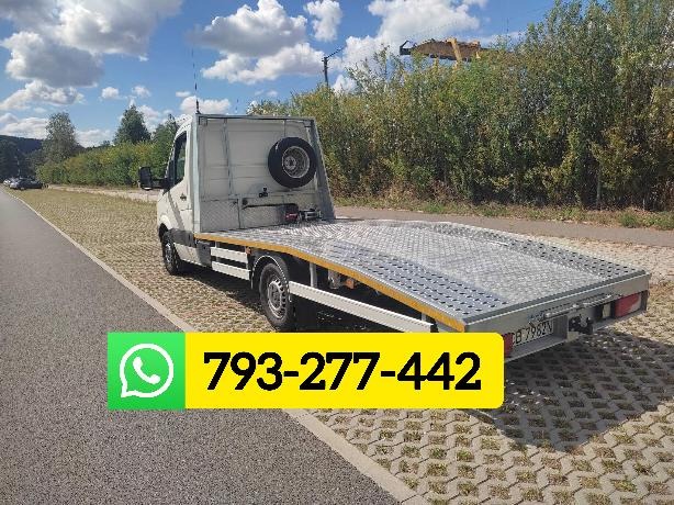 Biała platforma pojazdu z kołem zapasowym na tle zieleni i błękitnego nieba z chmurami, z numerem kontaktowym wyświetlonym na pierwszym planie.