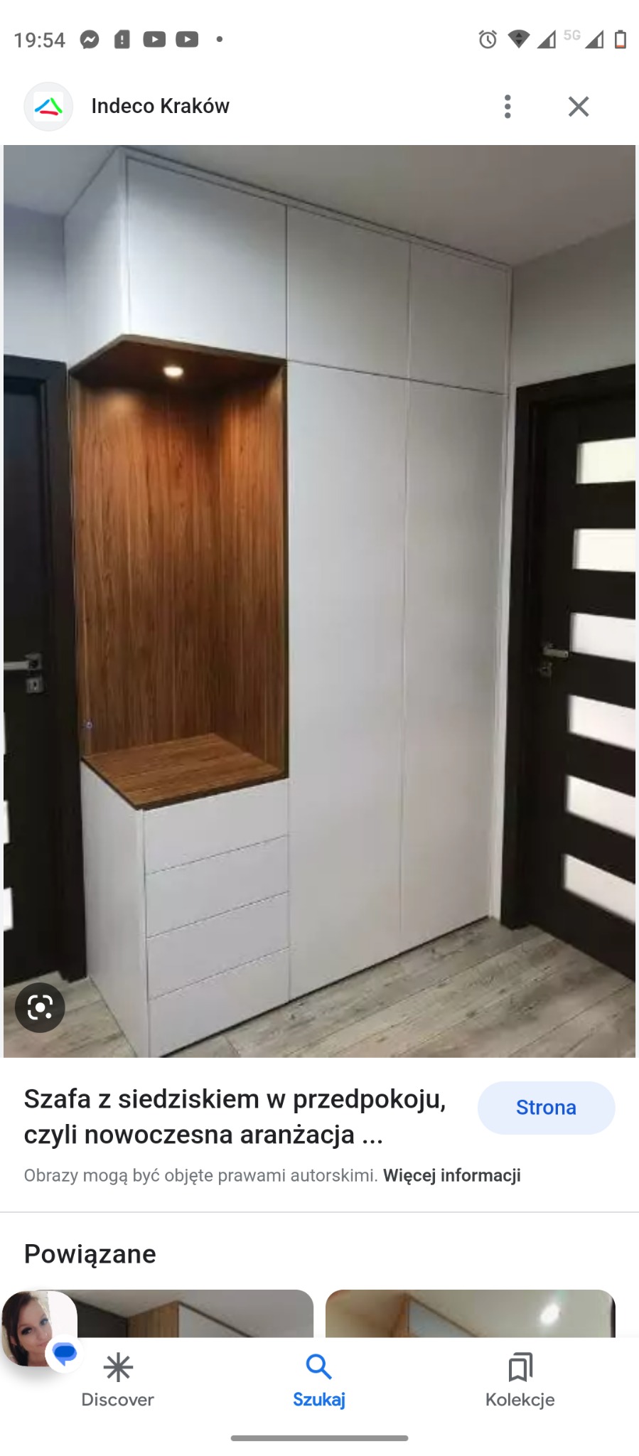 Biała szafa z drewnianą wnęką z siedziskiem i oświetleniem w przedpokoju, obok ciemne drzwi z przeszkleniami.