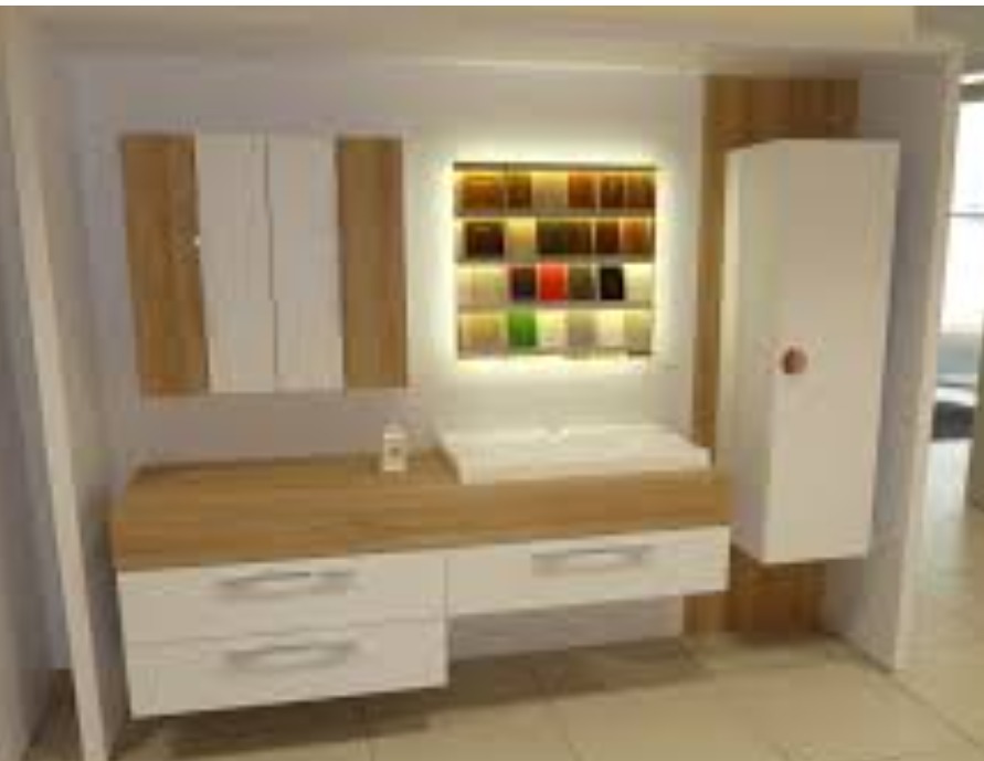 Nowoczesna zabudowa meblowa z białymi frontami i drewnianymi akcentami, oświetlona półka z próbkami materiałów w tle, widoczne dwie szuflady i szafka wisząca.