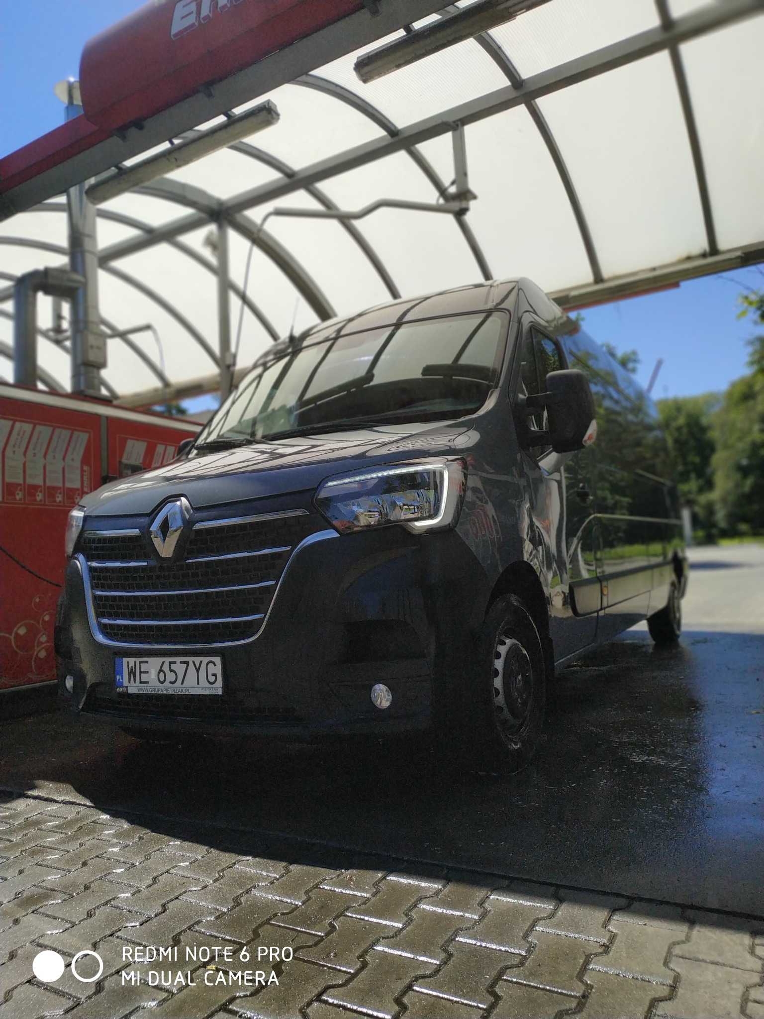 Czarny Renault Master L3H2, rocznik 2022, sfotografowany pod zadaszeniem myjni samochodowej, widoczna tablica rejestracyjna WE 657YG.