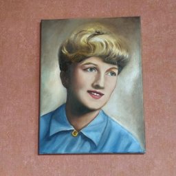 OdKarykatury DoMuralu - twoja wizja, moja pasja - Portret kobiety w błękitnej koszuli, namalowany farbami olejnymi na płótnie, zawieszony na ścianie o fakturze w odcieniach różu i beżu. Widoczne pociągnięcia pędzla.