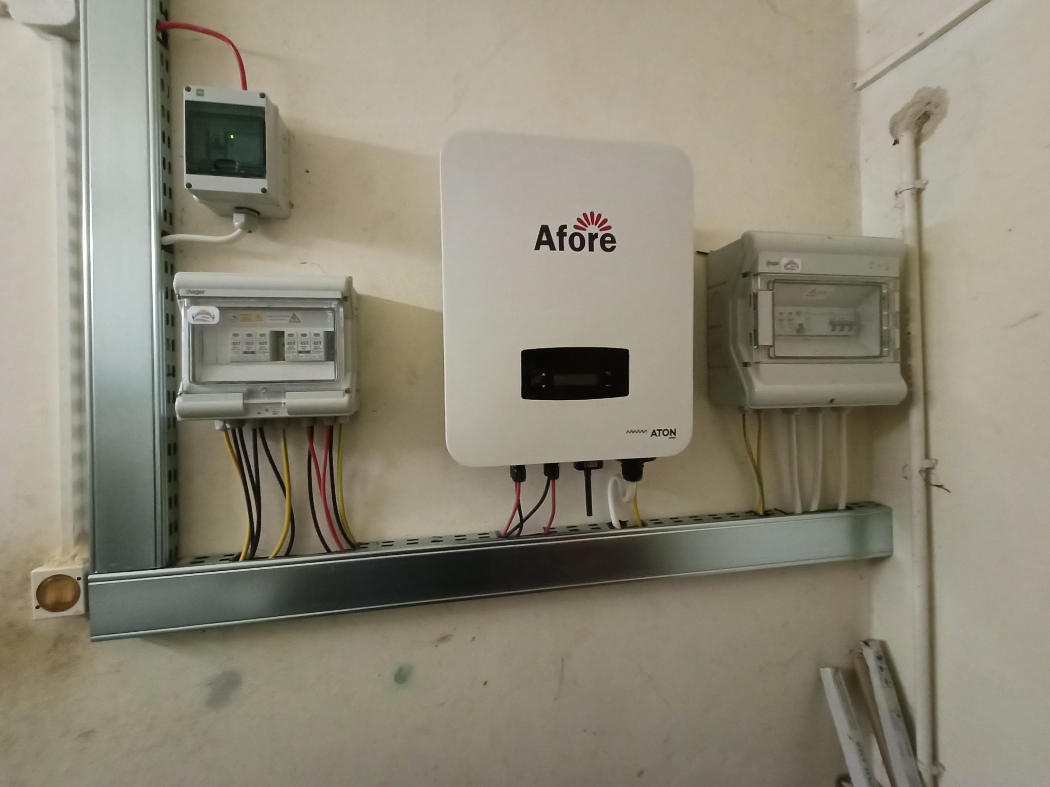 Zamontowany inwerter Afore z podłączonymi przewodami elektrycznymi w skrzynkach na metalowej szynie, widoczne zabezpieczenia elektryczne.