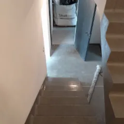 Schody wykończone w stylu mikrocementu w Osieku, widok z góry, widoczny worek z materiałem budowlanym Libet Decco w tle.