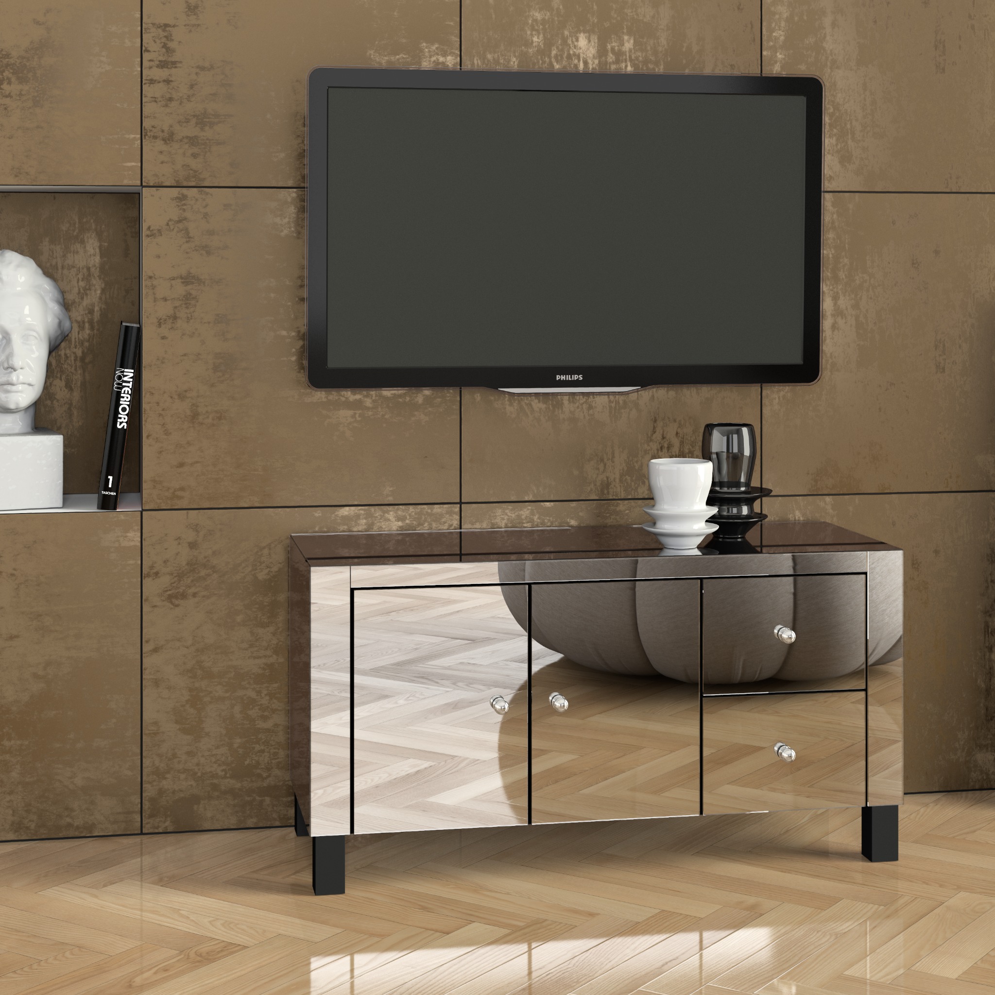 Nowoczesna komoda RTV z lustrzanymi frontami w Gdańsku, pod telewizorem, z dekoracjami w postaci wazonu i książki na tle ściany z dekoracyjną fakturą.