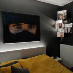 Sypialnia z ciemnymi ścianami, oświetlonymi półkami z książkami i obrazem kobiety z zasłoniętą twarzą, podświetlonym paskiem LED nad wezgłowiem łóżka.