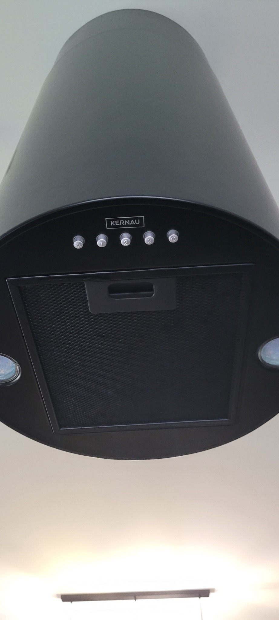 Czarny, cylindryczny okap kuchenny marki Kernau, widoczny od dołu, z widocznym filtrem i panel sterowania z czterema przyciskami.