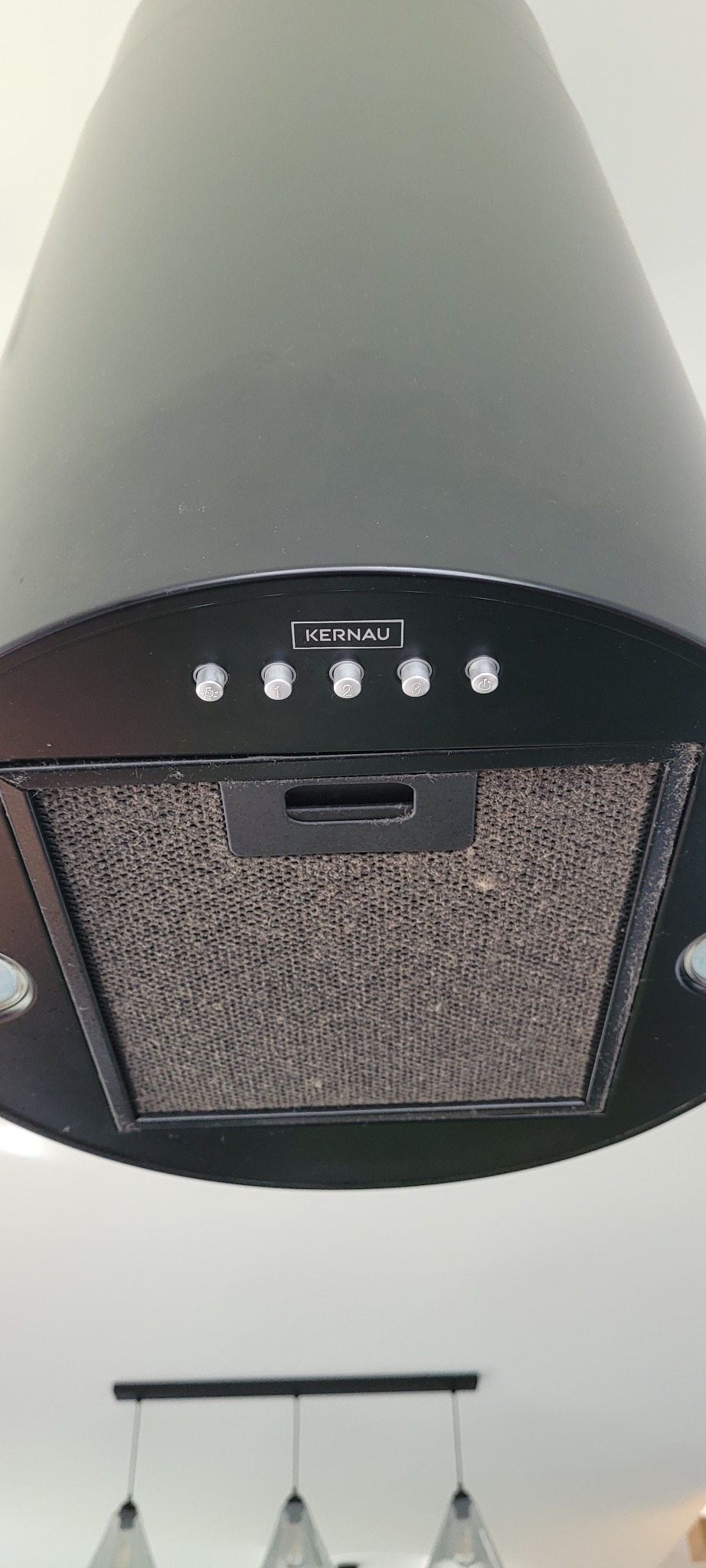 Brudny filtr okapu kuchennego marki Kernau, widoczne przyciski sterujące i oświetlenie podszafkowe.