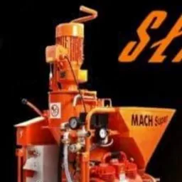 Pomarańczowa maszyna do nakładania tynków, model MACH Super, z widocznymi elementami hydraulicznymi i elektrycznymi na tle czarnego tła.