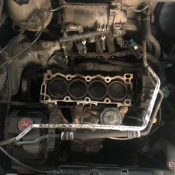 Widok z góry na otwarty silnik samochodowy z widocznymi cylindrami i elementami układu chłodzenia.