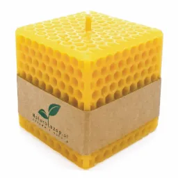 Żółta, kwadratowa świeca z wosku pszczelego o strukturze plastra miodu, owinięta papierową banderolą z logo 'Naturalszop.pl - zdrowe z natury'.
