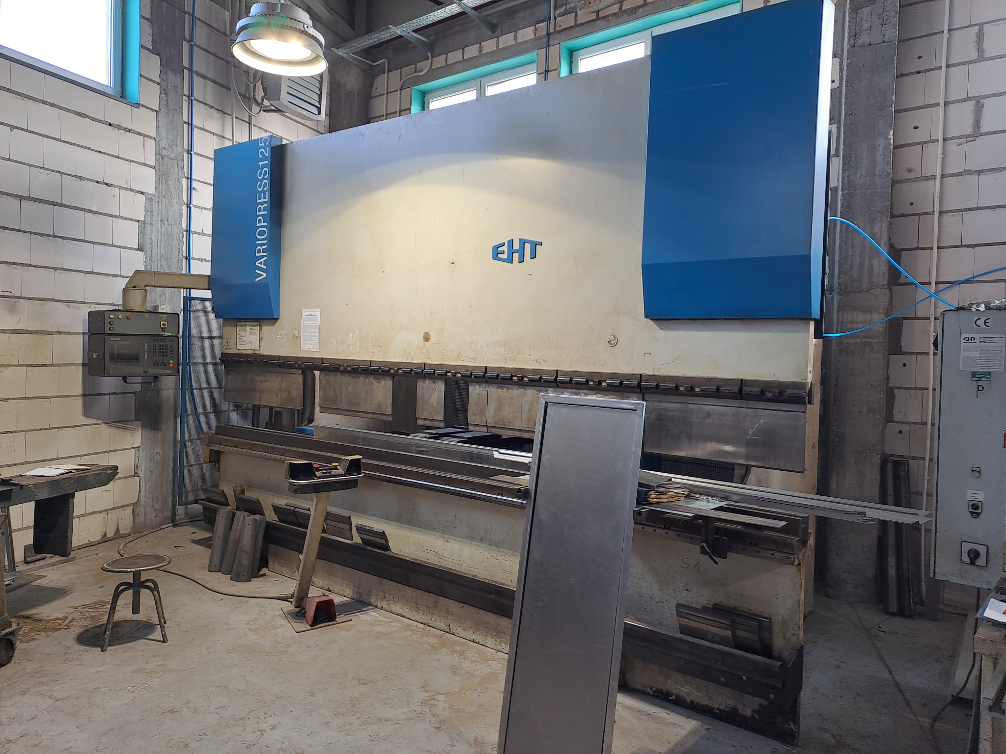 Duża prasa krawędziowa VARIO PRESS 125 w hali produkcyjnej, widoczne elementy sterujące i obrabiane metalowe detale.