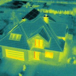 Michał Żurek Air Dimension Usługi dronem fotogrametria i termowizja - Termowizyjne zdjęcie domu jednorodzinnego z panelami słonecznymi na dachu, ukazujące straty ciepła przez okna i bramę garażową.